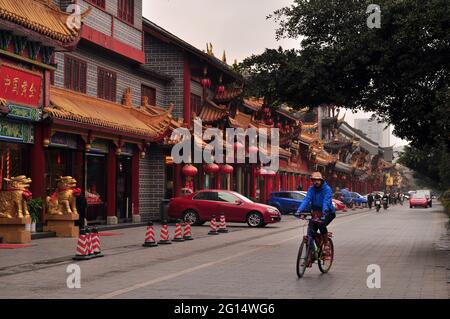 Ein Ausländer fährt mit dem Fahrrad auf einer chinesischen Straße Stockfoto