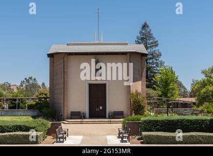 Santa Inez, CA, USA - 26. Mai 2021: Seminar in San Lorenzo. Vorderfassade mit Statue der Kirche unter blauem Himmel. In seinem grünen Garten gelegen. Stockfoto