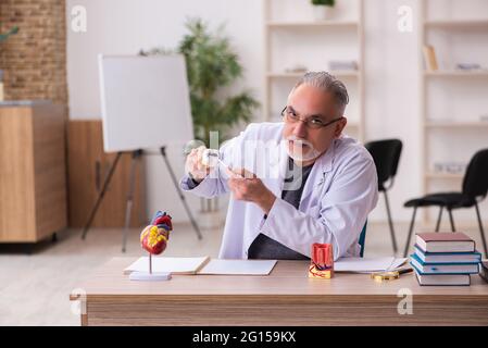 Alte Zahnarztlehrerin sitzt im Klassenzimmer Stockfoto