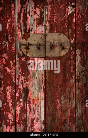 Detail einer verwitterten Holztür mit der Metallrückwand eines einfachen Schraubverschlosses, Sham Chung Wan, New Territories, Hong Kong Stockfoto