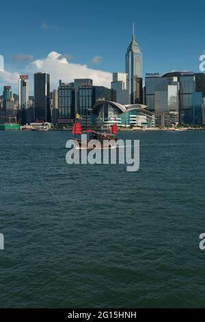 Das Aqua Luna, eine Nachbildung von chinesischem Müll, der für Kreuzfahrten verwendet wird, passiert das Kongress- und Ausstellungszentrum und die hohen Gebäude von Wan Chai, Hongkong Stockfoto