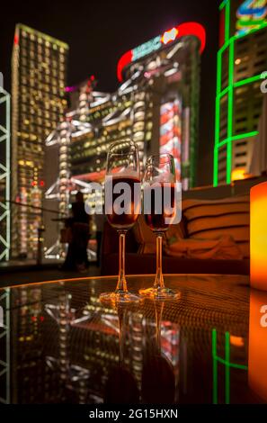 Zwei Gläser Sekt in der Nacht auf der Terrasse von Sevva, auf dem Dach des Prinzengebäudes, mit den beleuchteten Bürohochhäusern ... Stockfoto