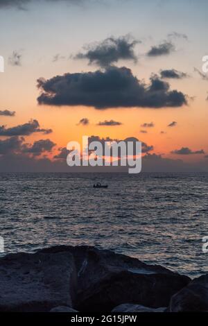 Sommeruntergang an der Sorrentinischen Küste bei Marina Lobra, Massa Lubrense, Italien mit Boot, das im Tyrrhenischen Meer vorbeifährt Stockfoto