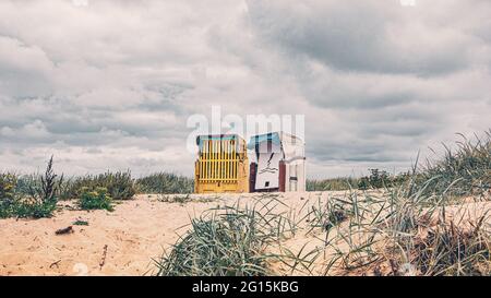 Zwei Liegestühle am wunderschönen Sandstrand im Herbst an der Nordsee. Strand mit Körben in Cuxhaven an der deutschen Nordseeküste. Stockfoto