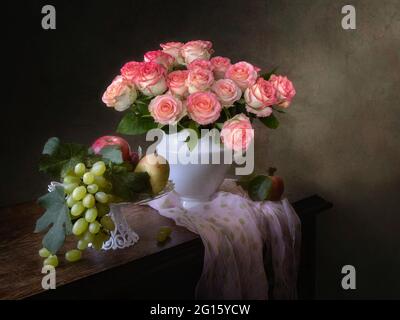 Stillleben mit schönen Bouquet von rosa Rosen und Früchten Stockfoto