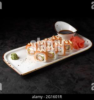 Roll Sushi Bonito - mit Käse, Gurke, gesalzenem Lachs und Thunfischflocken. Traditionelle japanische Sushi-Rollen auf schwarzem Hintergrund. Sushi-Menü. Japanisch Stockfoto