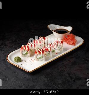 California Maki Sushi with Masago - Rolle aus Krabbenfleisch, Avocado, Gurke innen. Masago-roch Rogen auf schwarzem Hintergrund. Sushi-Menü. Japanisches Essen. Stockfoto