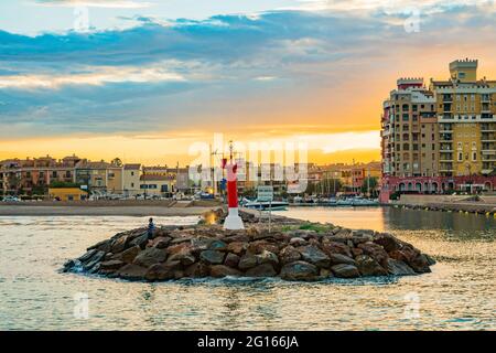Blick auf den Leuchtturm am Eingang zur Bucht von Port Saplaya bei einem farbenfrohen Sonnenuntergang. Valencia Stockfoto