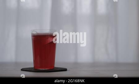 Red Berry Sekt im Glas mit Eis auf weißem Eichentisch, breites Foto Stockfoto