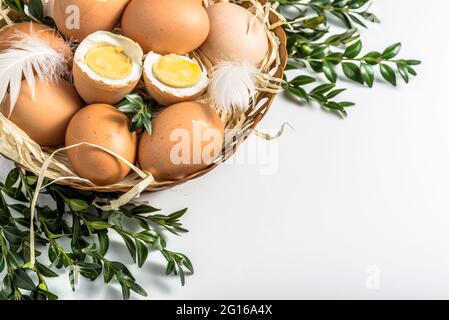 Bio-Eier im Korb und hartgekochtes Ei mit Eigelb, osterkost-Konzept Stockfoto