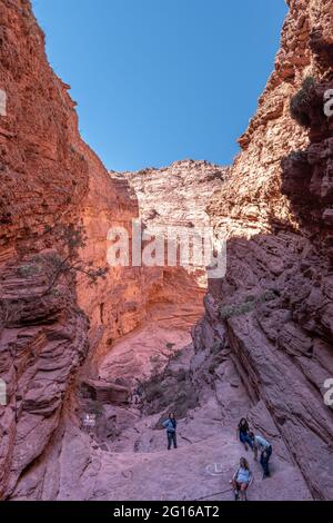 Touristen erkunden den Teufelskehlchen (Garganta del Diablo), eine rote Felsenschlucht auf der Straße zwischen Salta und Cafayate in der argentinischen Provinz Salta Stockfoto