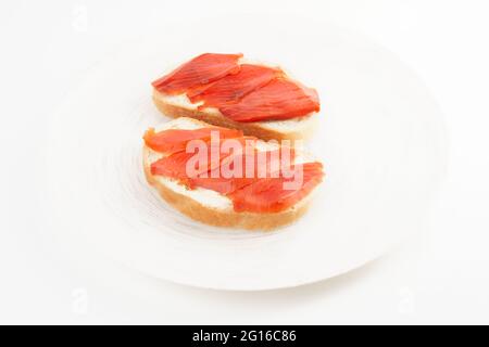 Zwei offene Sandwiches mit geräuchertem Lachs auf weißem Teller Stockfoto