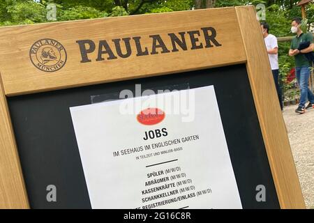 München, Deutschland. Juni 2021. Eröffnung der Gastronomie im Freien in Bayern herrscht Personalmangel, Arbeitsplätze werden angeboten, Mitarbeiter werden dringend gesucht. Teilzeit, Mini-Job, Jobs, Informationsschild vor dem Biergarten des Seehaus im Englischen Garten am Kleinhesseloher See in München, Gäste, Besucher. Englischer Biergarten in München, Quelle: dpa/Alamy Live News Stockfoto