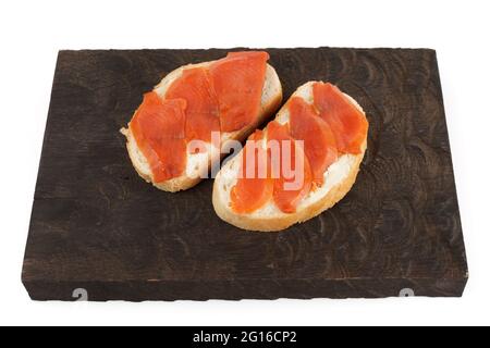 Offene Sandwiches mit geräucherter Forelle auf Holzbrett, isoliert auf weißem Hintergrund Stockfoto