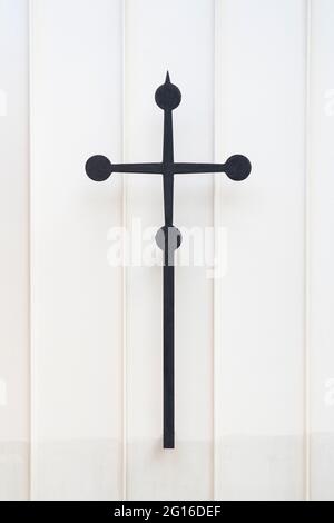 Katholisches Metallkreuz an einer weißen Wand Stockfoto