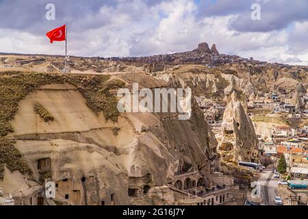 Häuser in Feenkaminen und einzigartige Felsformationen mit türkischer Flagge in Göreme, Kappadokien, Türkei Stockfoto