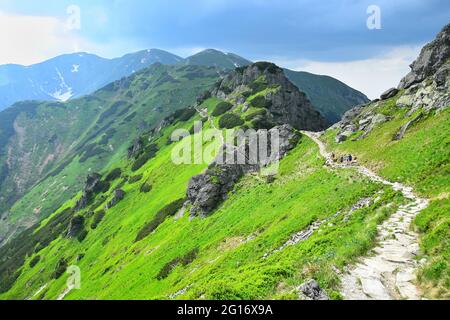 Der Weg vom Berg Kasprov führt entlang der polnisch-slowakischen Grenze. Einige Wanderer auf dem Weg. Hohe Tatra, Polen. Stockfoto