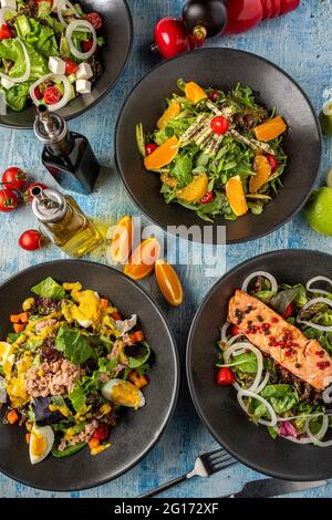 Vier verschiedene Salatsorten werden frisch auf dem Blue Stone-Tisch serviert Stockfoto