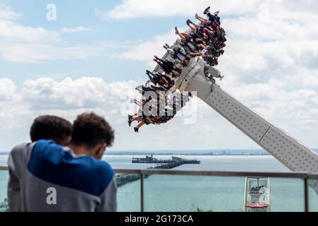 Southend on Sea, Essex, Großbritannien. Juni 2021. Nach dem heftigen Regen des Vortages und einem bewölkten Morgen hat sich der Himmel über Southend in einen warmen und sonnigen Tag verwandelt. Thrill-Rider genießen die Axis-Fahrt in Adventure Island. Paar beobachten von der Aussichtsplattform Stockfoto