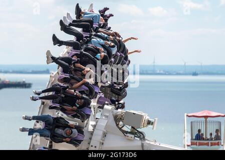 Southend on Sea, Essex, Großbritannien. Juni 2021. Nach dem heftigen Regen des Vortages und einem bewölkten Morgen hat sich der Himmel über Southend in einen warmen und sonnigen Tag verwandelt. Thrill-Rider genießen die Axis-Fahrt in Adventure Island. Muslimische Frauen mit Hijabs und Gesichtsmaske Stockfoto