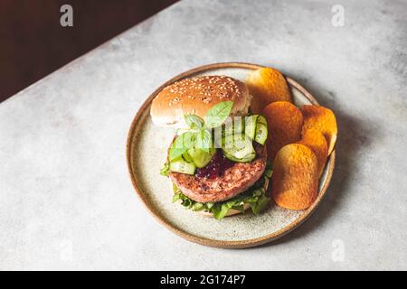 Hausgemachter, offener Rindfleisch-Burger mit Gemüse auf hellem Betongrund. Draufsicht, Kopierbereich. Stockfoto