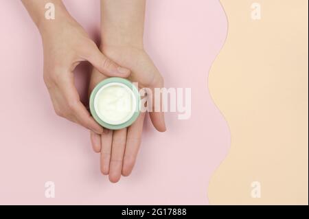 Ein offenes Glas mit Creme in der Hand einer Frau. Bio-Kosmetik für die Hautpflege. Schönheitskonzept Stockfoto