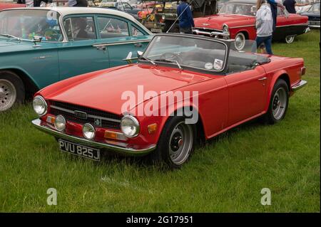 Triumph TR6 in Rot mit Punktleuchten mit abgesenktem Dach auf einer Oldtimer-Show Stockfoto