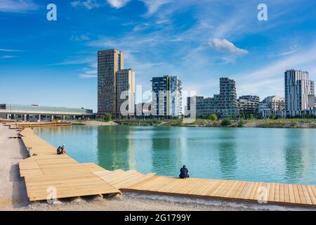 Wien, Wien: 84 m hoher hölzerner Wolkenkratzer HoHo Holzhochhaus, höchster hölzerner Wolkenkratzer der Welt, im neuen Stadtteil Seestadt Aspern, Teich Asperner SE Stockfoto