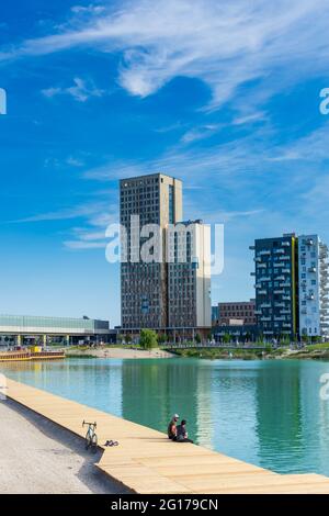 Wien, Wien: 84 m hoher hölzerner Wolkenkratzer HoHo Holzhochhaus, höchster hölzerner Wolkenkratzer der Welt, im neuen Stadtteil Seestadt Aspern, Teich Asperner SE Stockfoto