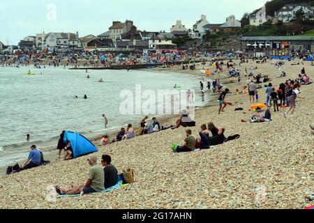 Lyme Regis, Großbritannien. Juni 2021. An einem sehr warmen und bewölkten Tag im Lyme Regis in East Devon werden Urlauber beim Schlafen und Spazierengehen am Strand und am Meer liegend gesehen. Bildquelle: Robert Timoney/Alamy Live News Stockfoto