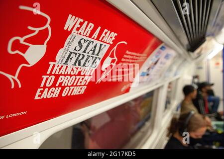 London, Großbritannien, 3. Juni 2021: Während die meisten Menschen Gesichtsmasken in öffentlichen Verkehrsmitteln tragen, sind einige nicht auf gesundheitliche Probleme oder eine Rebellion gegen Regierungsratschläge zurückzuführen. Ein Aufkleber der Join the White Rose-Bewegung rät 'Stay Free' und entlarvt ein Plakat von Transport for London und dem Bürgermeister von London, auf dem die Menschen aufgefordert werden, Gesichtsmasken zu tragen, um die Ausbreitung von Covid zu reduzieren. Anti-Vaxxer und Lockdown-Skeptiker kämpfen gegen wissenschaftliche Gutachten und eine mögliche dritte Welle von Covid-Infektionen in Großbritannien. Anna Watson/Alamy Stockfoto