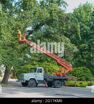 Dnepropetrovsk, Ukraine - 05.27.2021: Ein kommunaler Arbeiter in Schutzausrüstung führt gefährliche Arbeiten durch, um eine Unterbrechung der Stromversorgung gri zu beseitigen Stockfoto