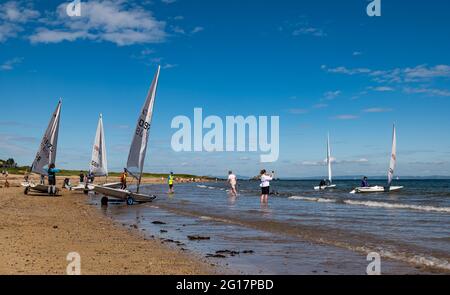 Segelregatta mit Segeljollen wird am West Bay Beach, North Berwick, East Lothian, Schottland, Großbritannien gestartet Stockfoto