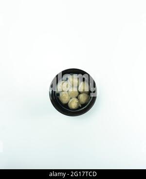 Fleischbällchen aus Rindfleisch werden in einer schwarzen Schüssel auf weißem Hintergrund serviert. Stockfoto