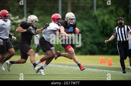 Hamburg, Deutschland. Juni 2021. Das Team der Hamburger Sea Devils (rote Helme) spielt bei einem American Football-freundlichen Spiel gegen Berlin Thunder (silberne Helme). Quelle: Daniel Reinhardt/dpa/Alamy Live News Stockfoto