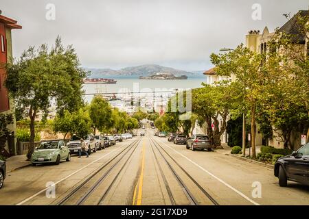 Leere Straße und die Seilbahn auf der Hyde Street mit Blick auf das Meer und die Insel Alcatraz Stockfoto