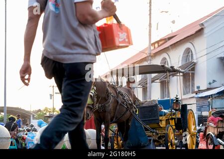 Yogyakarta, indonesien, januari 2021 : der Kutscher der Pferdekutsche, der am Nachmittag am Straßenrand ruht Stockfoto