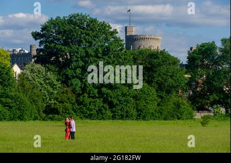 Eton, Windsor, Britannien. Juni 2021. Ein Paar umarmt in der Nachmittagssonne unter den wachsamen Augen von Windsor Castle. Quelle: Maureen McLean/Alamy Live News Stockfoto