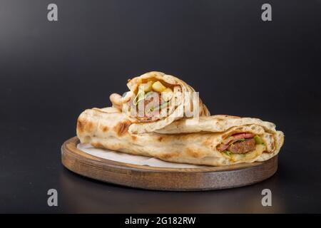 Knusprige Hähnchenwickel Fast Food Fleisch Holzplatte schwarz hintergrundgeschliffen Stockfoto
