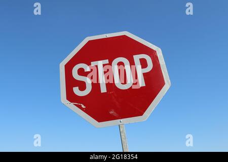 Nahaufnahme eines Stoppschildes vor einem klaren blauen Himmel Stockfoto