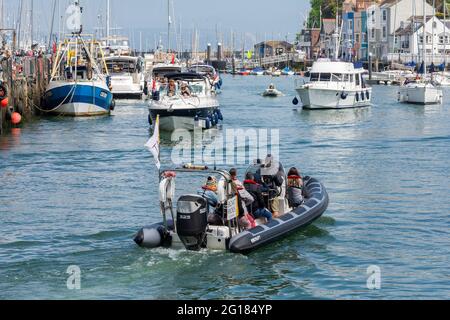 Weymouth on a hot and sunny crowded Bank Holiday Weekend. Crowds flocked to the Dorset UK holiday resort. Boat ride RIB manoeuvring in a busy Weymouth Harbour. Credit: Stephen Bell/Alamy Stockfoto