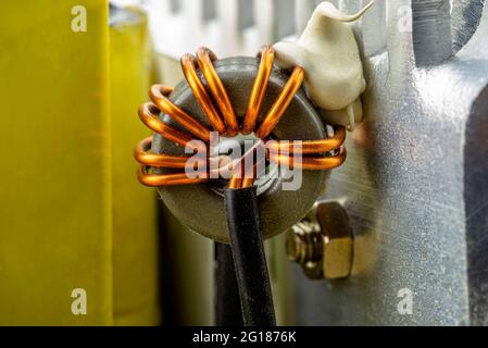 Eine Induktivität, Ringspule auf einem Ring mit sichtbarer Kupferrolle, gewickelt auf einer Magnetspule. Stockfoto