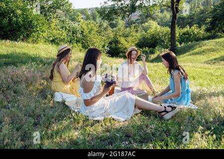 Ideen Für Sommerparty Im Freien. Sichere und festliche Möglichkeiten, kleine Treffen im Freien mit Freunden zu veranstalten. Menschen kommen sicher zusammen. Junge Frauen Mädchen Freunde Stockfoto