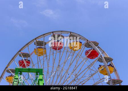 Santa Monica, CA, USA - 20. Juni 2013: Nahaufnahme von farbenfrohen Fähren, die auf dem Pier vor blauem Himmel ragen. Stockfoto