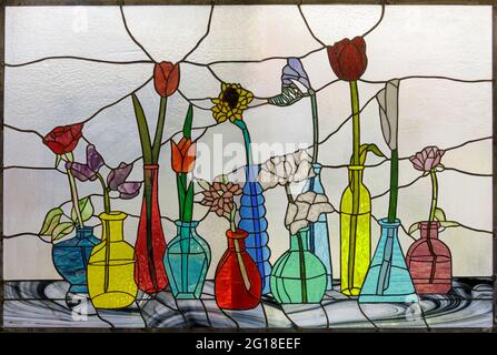Buntglasfenster mit Blumen in Vasen Stockfoto