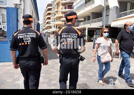 Zwei freiwillige Agenten des Katastrophenschutzes von Calafell, die dafür sorgen, dass die Menschen Masken auf der Straße tragen.die Calafell Katastrophenschutz Freiwillige Vereinigung ist eine Gruppe von Männern und Frauen, die freiwillig und ohne Geld arbeiten, um bei Notfällen und Schutzdiensten zu helfen, die in der Stadt mit logistischen auftreten können Hilfe vom stadtrat. Es ist auch eine Ergänzung der Sicherheit und des Schutzes der lokalen Polizei und bei der Pandemiehilfe, um den Zugang zu Impfungen und die Kontrolle der Öffentlichkeit in Konzerten, Messen und Kongressen zu kontrollieren. Stockfoto