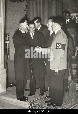 Das Münchner Abkommen 1938: Der britische Premierminister Neville Chamberlain schief Hände mit Adolf Hitler Stockfoto