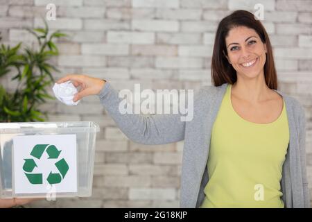 Bewusste Frau, die Papier von anderen Abfällen trennt Stockfoto