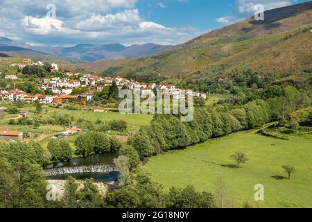 Schöne Landschaft des Dorfes Alvoco das Várzeas in Portugal, mit dem Fluss Alvôco im Vordergrund und den Hügeln der Serra da Estrela Stockfoto
