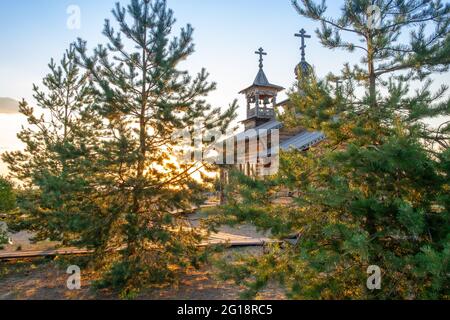 Kleine russisch-orthodoxe Holzkirche. Hölzerne orthodoxe Kirche gegen blauen Himmel am sonnigen Tag - Bild Stockfoto
